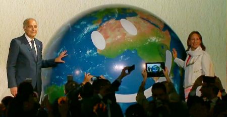Happy planet. Die französische Umweltminsterin Ségolene Royal übergibt die Verantwortung für das Wohlergehen des Planeten an ihren Nachfolger als COP Präsident, den marokkanischen Aussenminister Salaheddine Mezouar. (Foto: Screenshot)